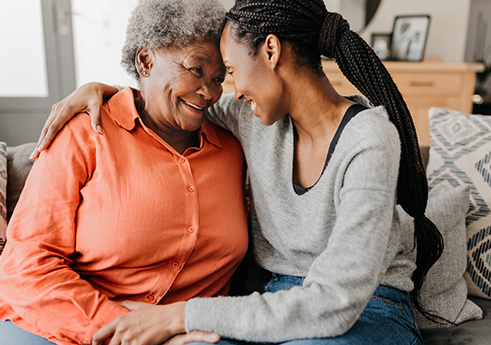 A senior woman and her adult daughter are hugging