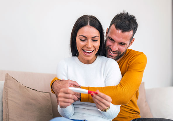 An excited couple seeing the positive results of a pregnancy test