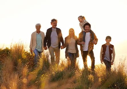 A generational family outside smiling