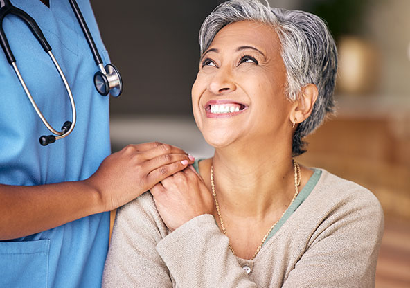 Middle aged woman getting good news from medical staff after breast exam.